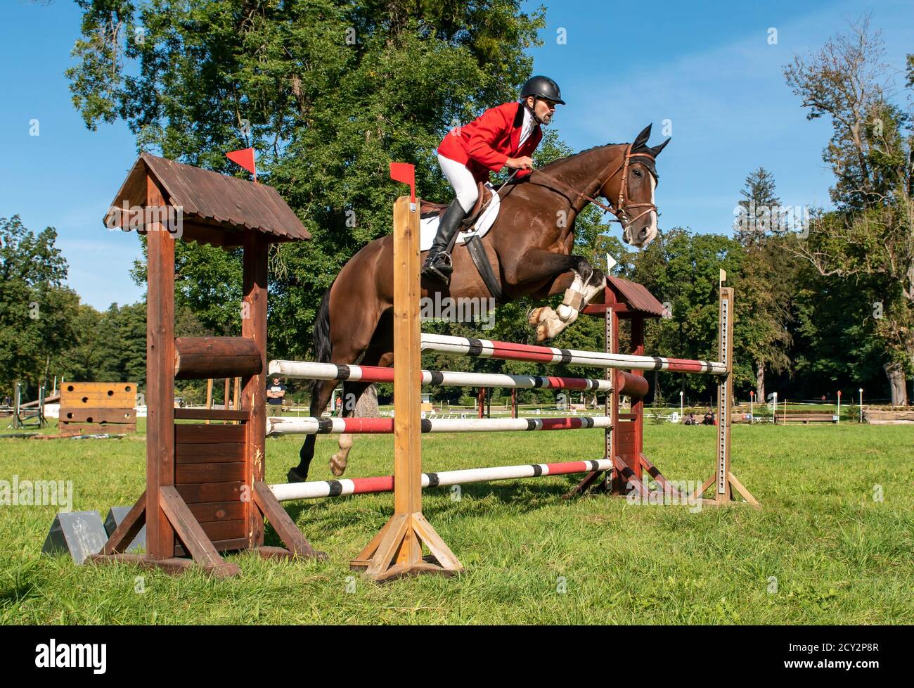 Low-angle view of male rider and horse jumping over a fence at a showjumping eventing trial, Czech Republic Stock Photo