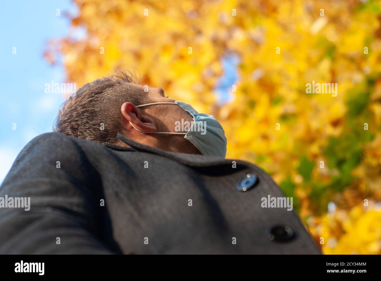 A man in a medical mask in an autumn Park, close-up Stock Photo - Alamy