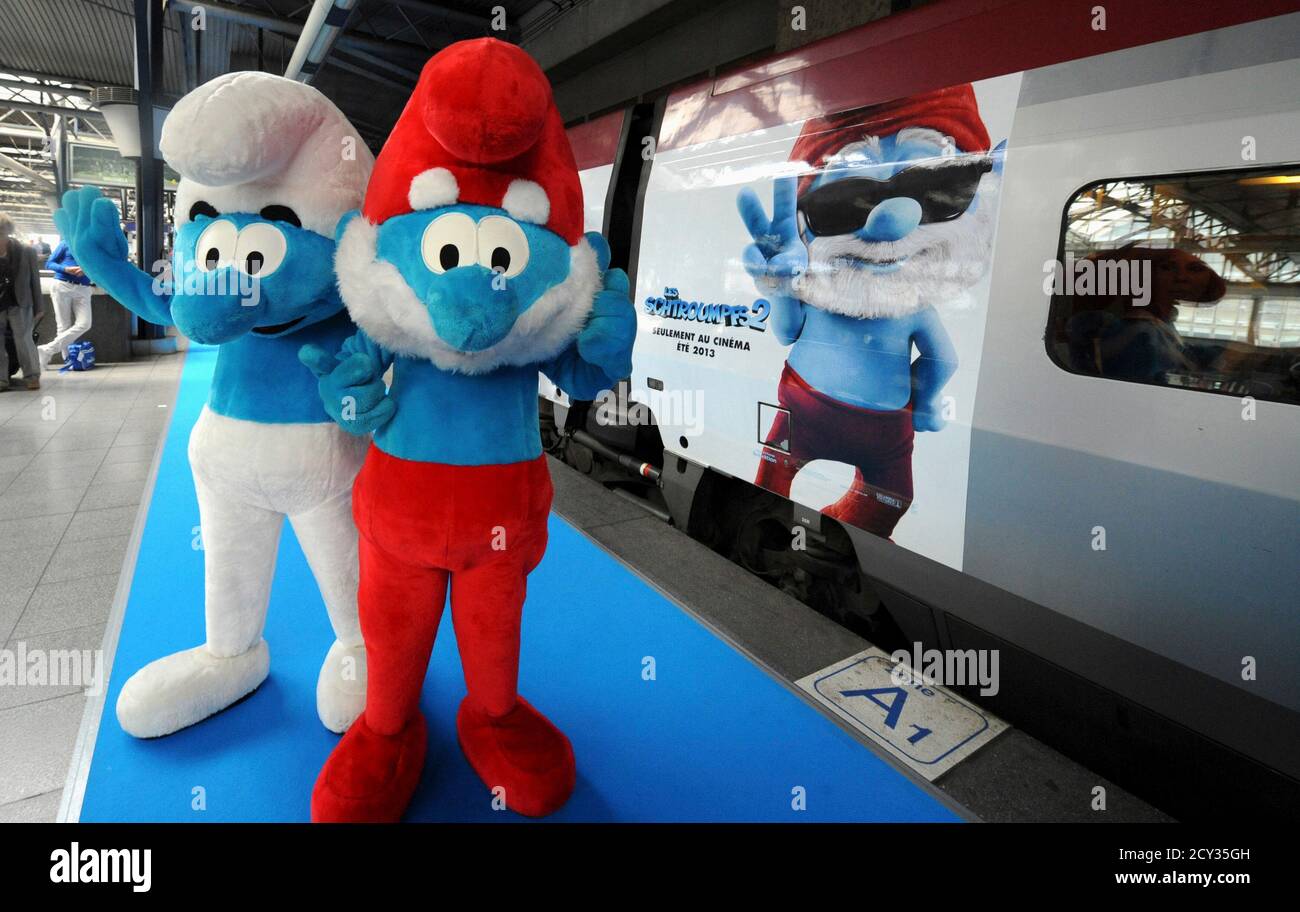 Life Size Characters Of Papa Smurf R And A Smurf Pose Next To A Thalys Train Decorated For The Film The Smurfs 2 During A Celebration For The Birthday Of Peyo The Creator