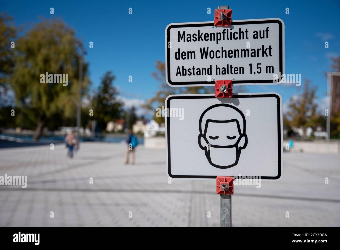 German indication sign at market place 'Face mask and a distance of 1,5 meters is required' Stock Photo