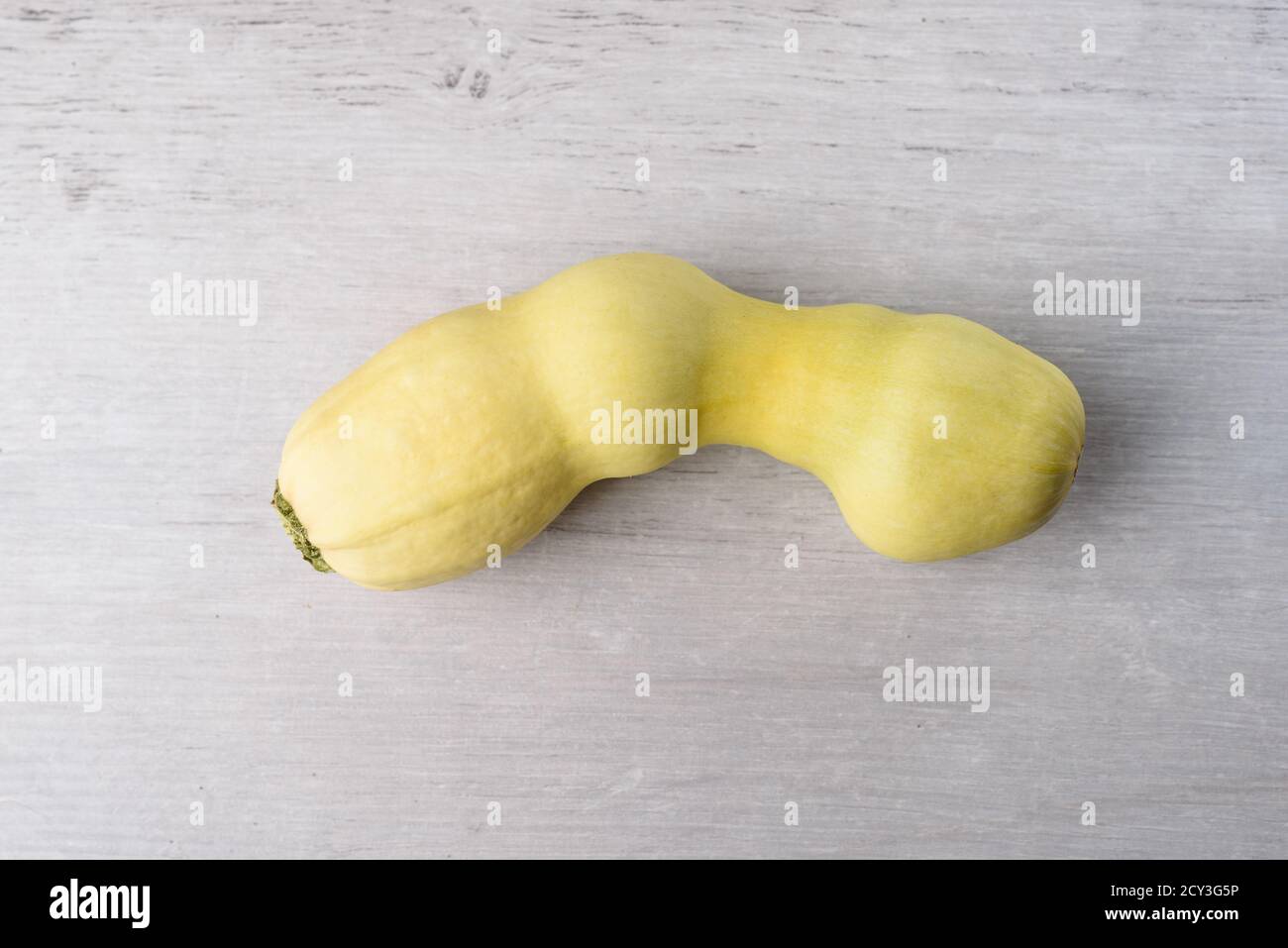 Ugly vegetable marrow, on a gray wooden background. Ugly food concept, top view, copy space. Stock Photo