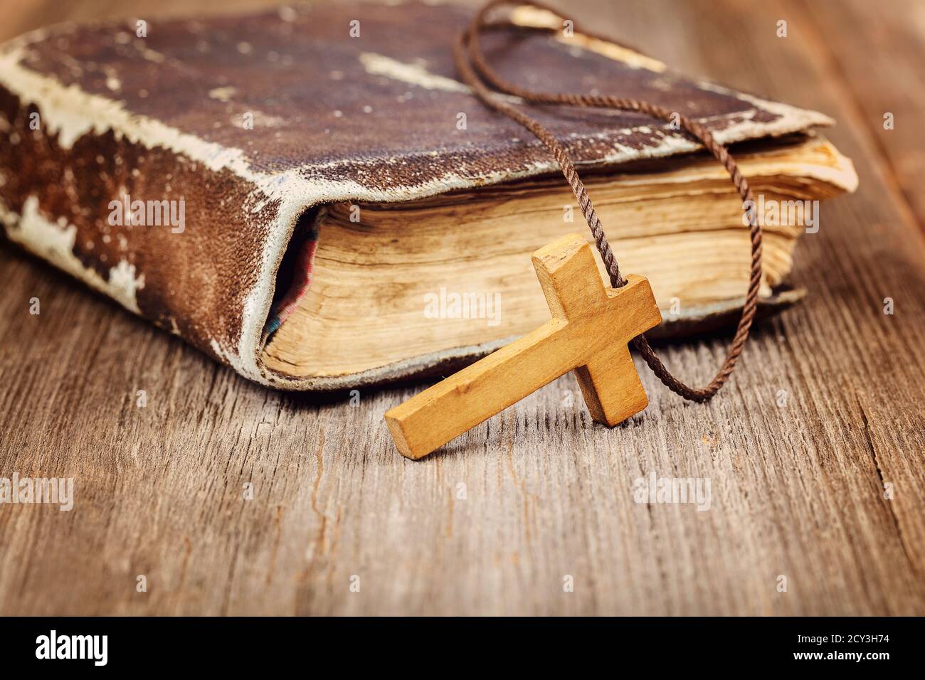 Ancient holy book of a wooden cross on a cord on a wooden background Stock  Photo - Alamy