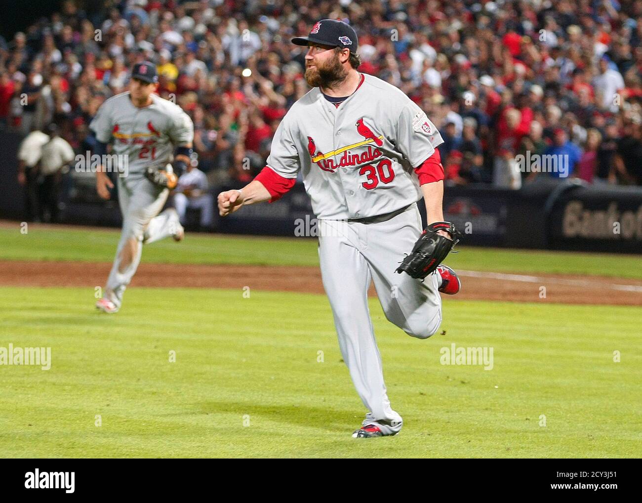St. Louis Cardinals pitcher Jason Motte (R) and his teammate Allen Craig  run off the field as they celebrates their win over the Atlanta Braves for  the wild card at their MLB