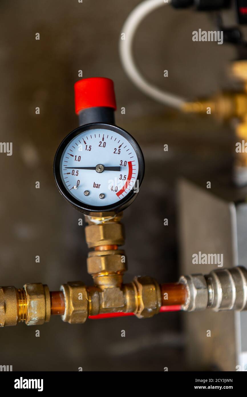 Pressure gauge connected to brass pipe in boiler house for home heating