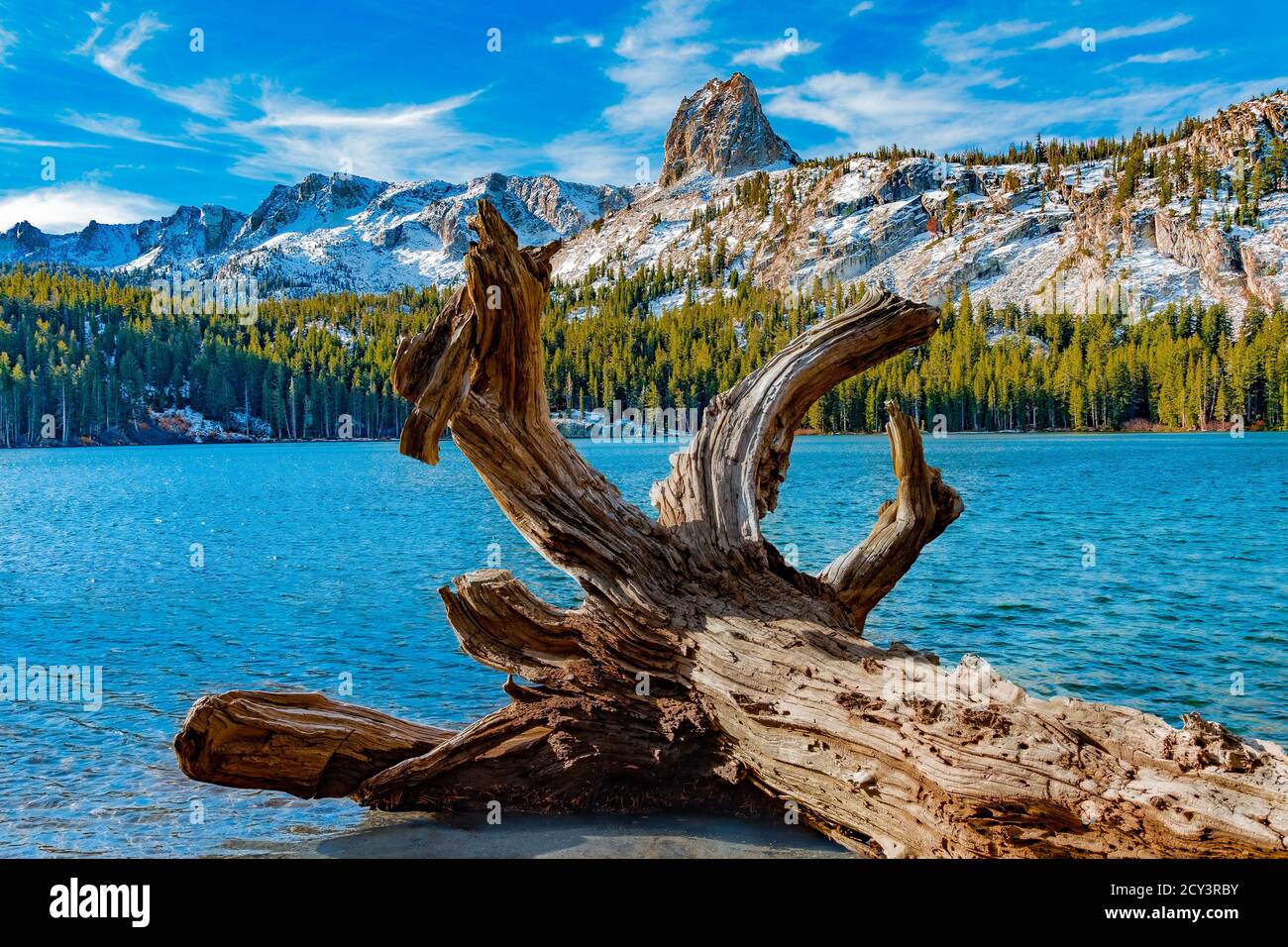Crystal Crag peak juts out of the snowy mountain over Lake George in the Mammoth Lakes of California in the Autumn. Stock Photo