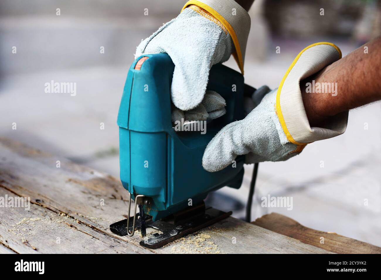 Carpenter with fretsaw at outdoor work. close-up. Construction details of male worker or handy man with power tools. Stock Photo