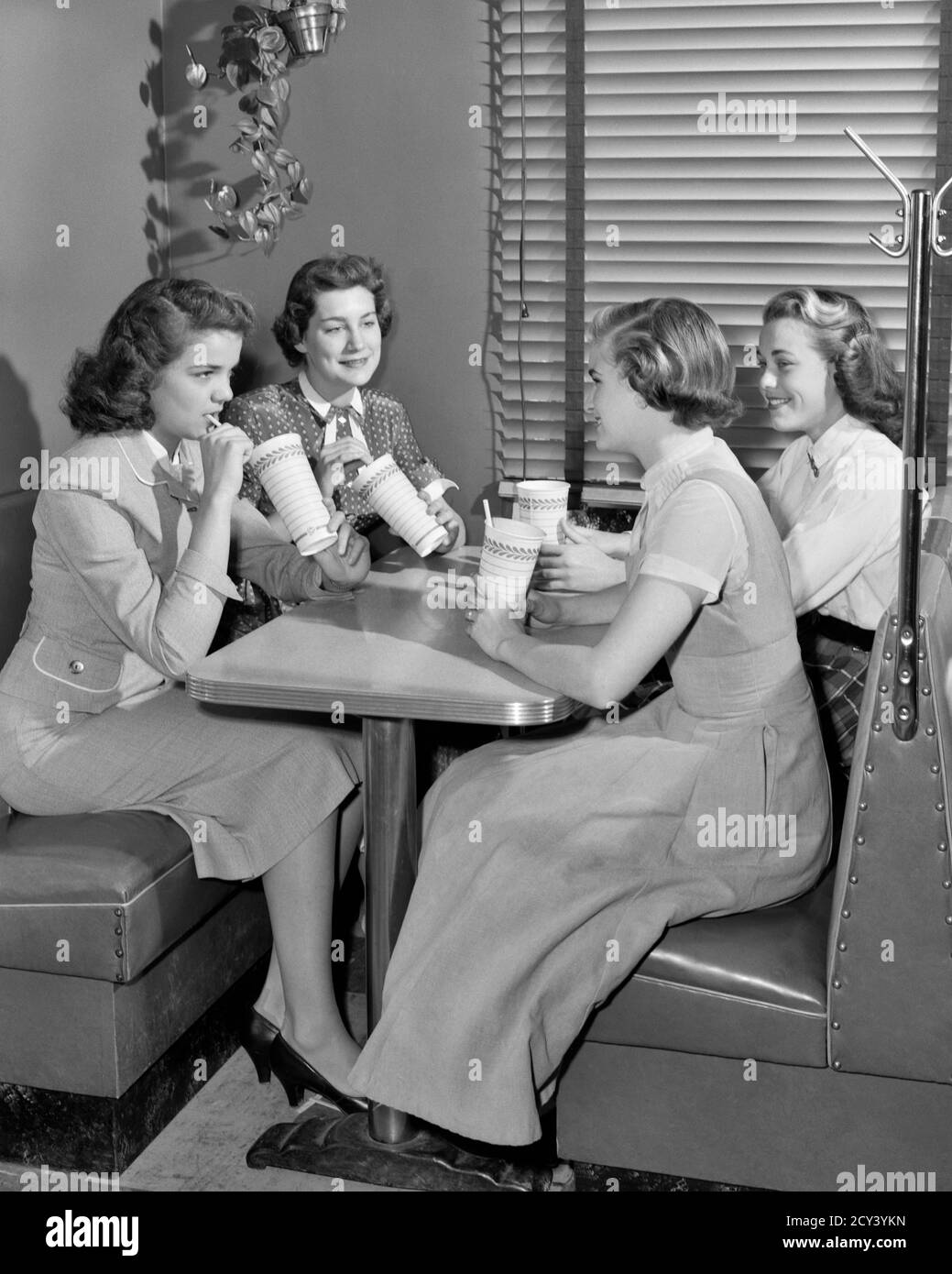 1950s FOUR TEENAGE GIRLS FRIENDS SITTING BOOTH AT SODA FOUNTAIN TALKING DRINKING MILKSHAKES PAPER CUPS PAPER STRAWS  - f6766 HAR001 HARS COMMUNITY DINER SUBURBAN SODA FOUNTAIN URBAN OLD TIME NOSTALGIA OLD FASHION 1 JUVENILE STYLE WELCOME COMMUNICATION YOUNG ADULT MILKSHAKE TEAMWORK JOY LIFESTYLE CELEBRATION FEMALES COPY SPACE FRIENDSHIP FULL-LENGTH LADIES PERSONS TEENAGE GIRL CUPS STRAWS B&W SCHOOLS BOOTH HAPPINESS UNIVERSITIES CHOICE ENJOYING LEADERSHIP RECREATION AT HIGH SCHOOL HIGH SCHOOLS HIGHER EDUCATION CONNECTION CONCEPTUAL MILKSHAKES PARLOR STYLISH COLLEGES ICE CREAM GROWTH JUVENILES Stock Photo