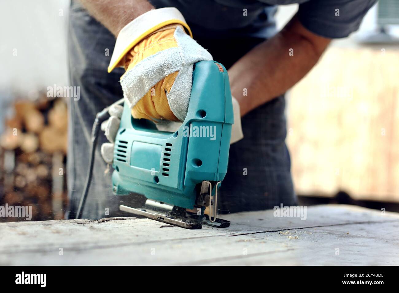 Carpenter using fretsaw for cutting wooden boards. Construction details of male worker or handy man with power tools.Work process in the carpentry Stock Photo