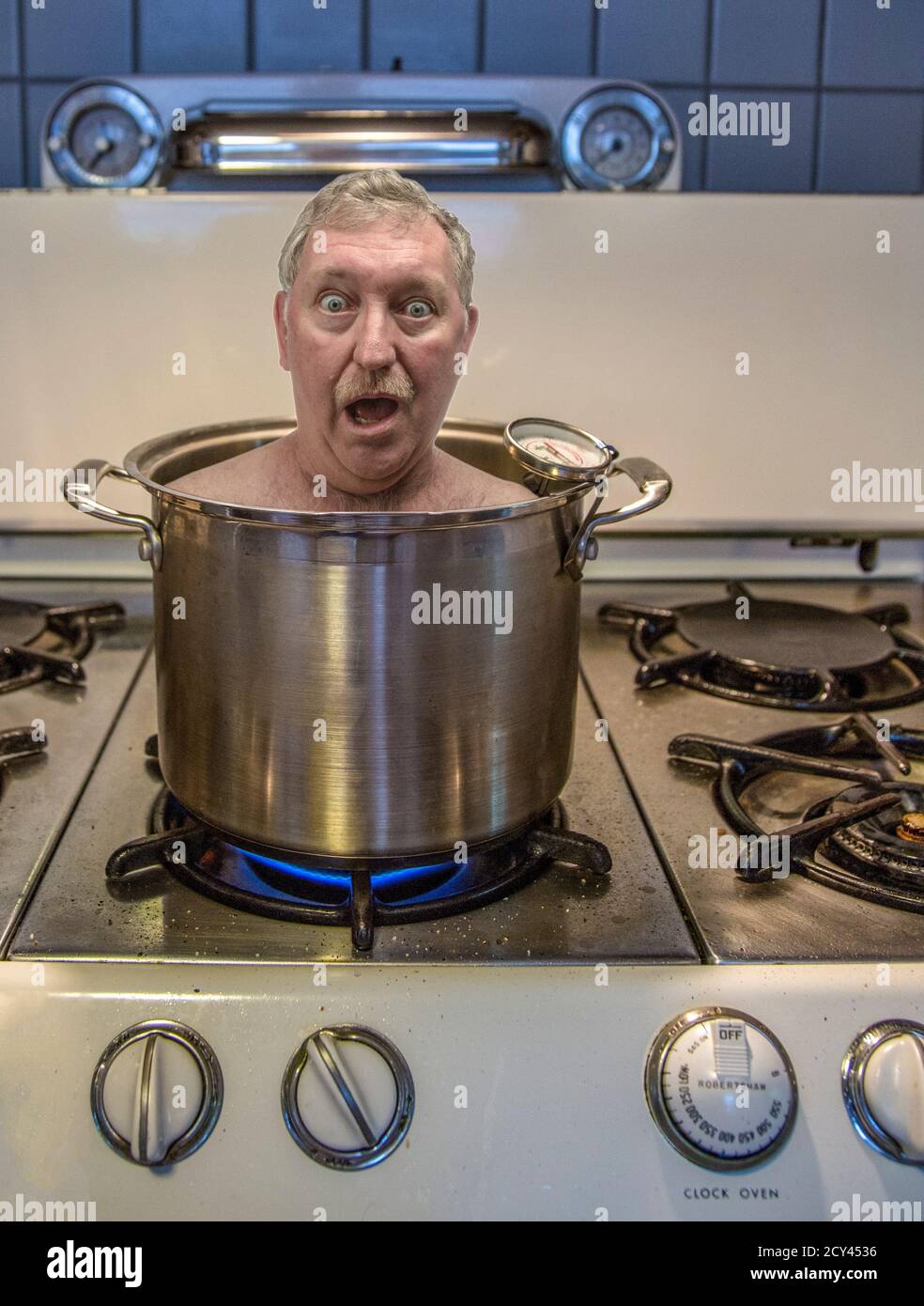 Man s head shown in pot of boiling water on stove. Studio image. Apr 23