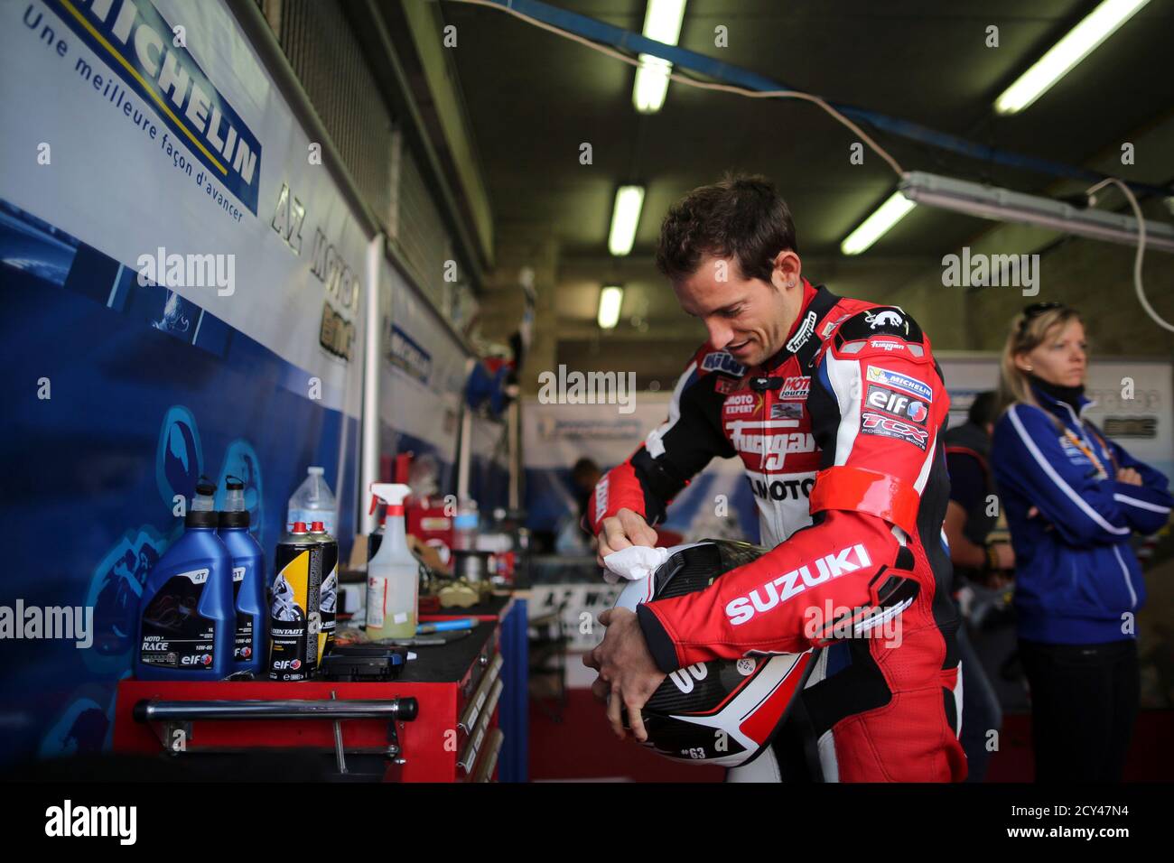 Olympic pole-vault champion Renaud Lavillenie of France cleans his helmet  during the warm-up session of the 36th Le Mans 24 hours motorcycle  endurance race in Le Mans, western France September 21, 2013.