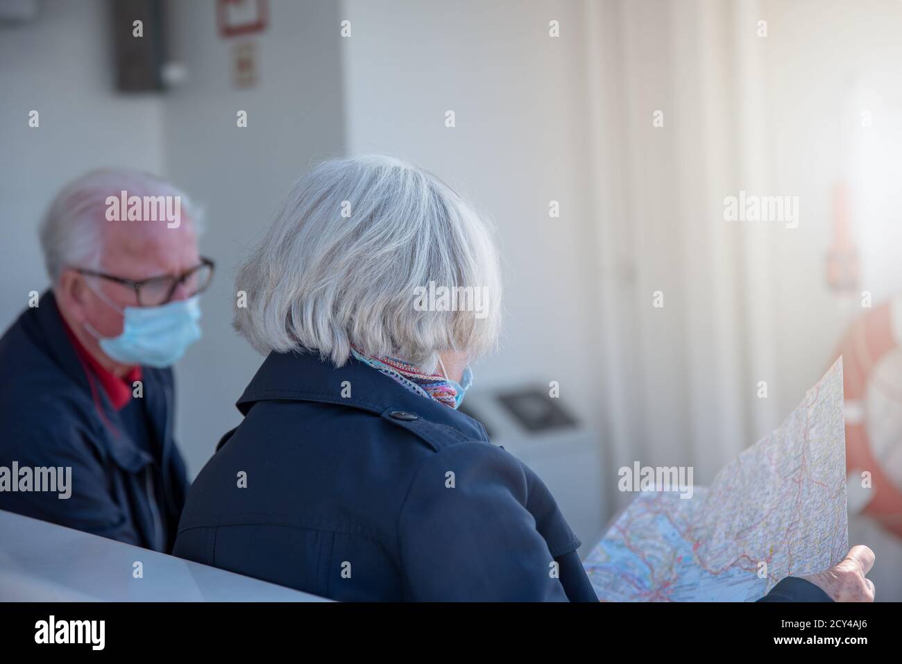 Tourist senior couple with face masks looking on map Stock Photo - Alamy