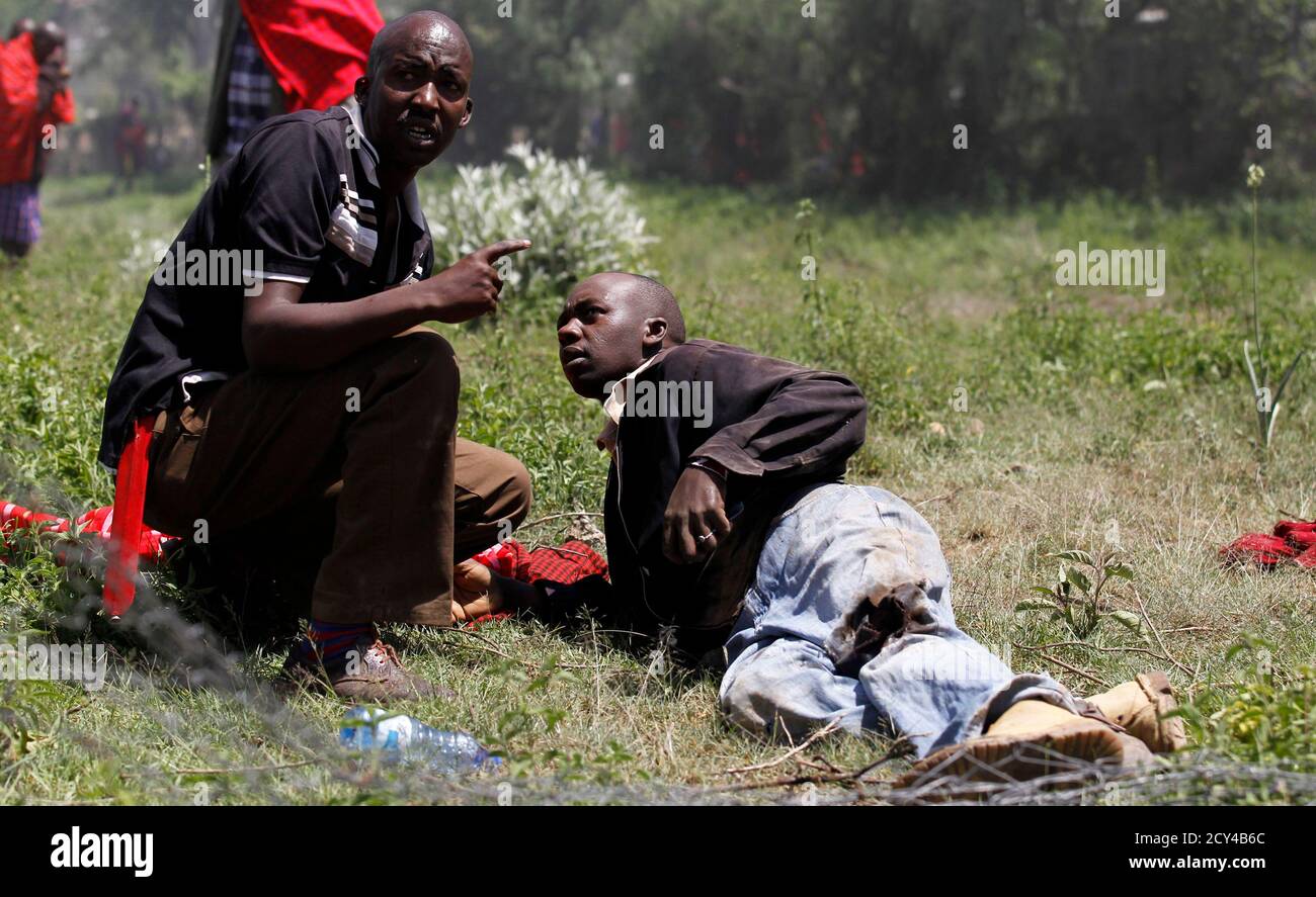 ATTENTION EDITORS - VISUAL COVERAGE OF SCENES OF INJURY OR DEATH  A resident attempts to assist a man shot and injured during protests to oust Narok county Governor Samuel Tunai in Narok, Kenya, January 26, 2015.  At least seven people were injured on Monday in clashes between Kenyan police and protesters from the Maasai ethnic group who accuse a local governor of corrupt handling of tourism funds from the Maasai Mara game reserve, the Kenya Red Cross said. REUTERS/Thomas Mukoya (KENYA - Tags: CIVIL UNREST POLITICS CRIME LAW TRAVEL) Stock Photo