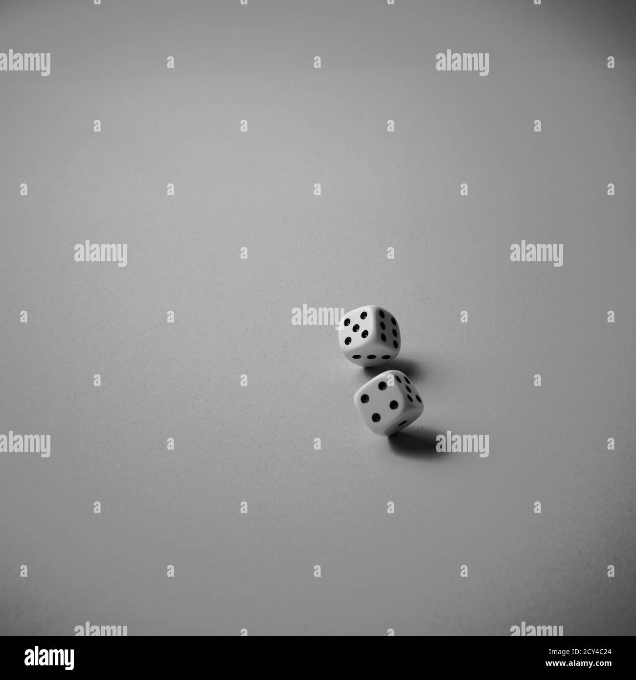 Two dice rolling on white background, black and white, minimalism Stock