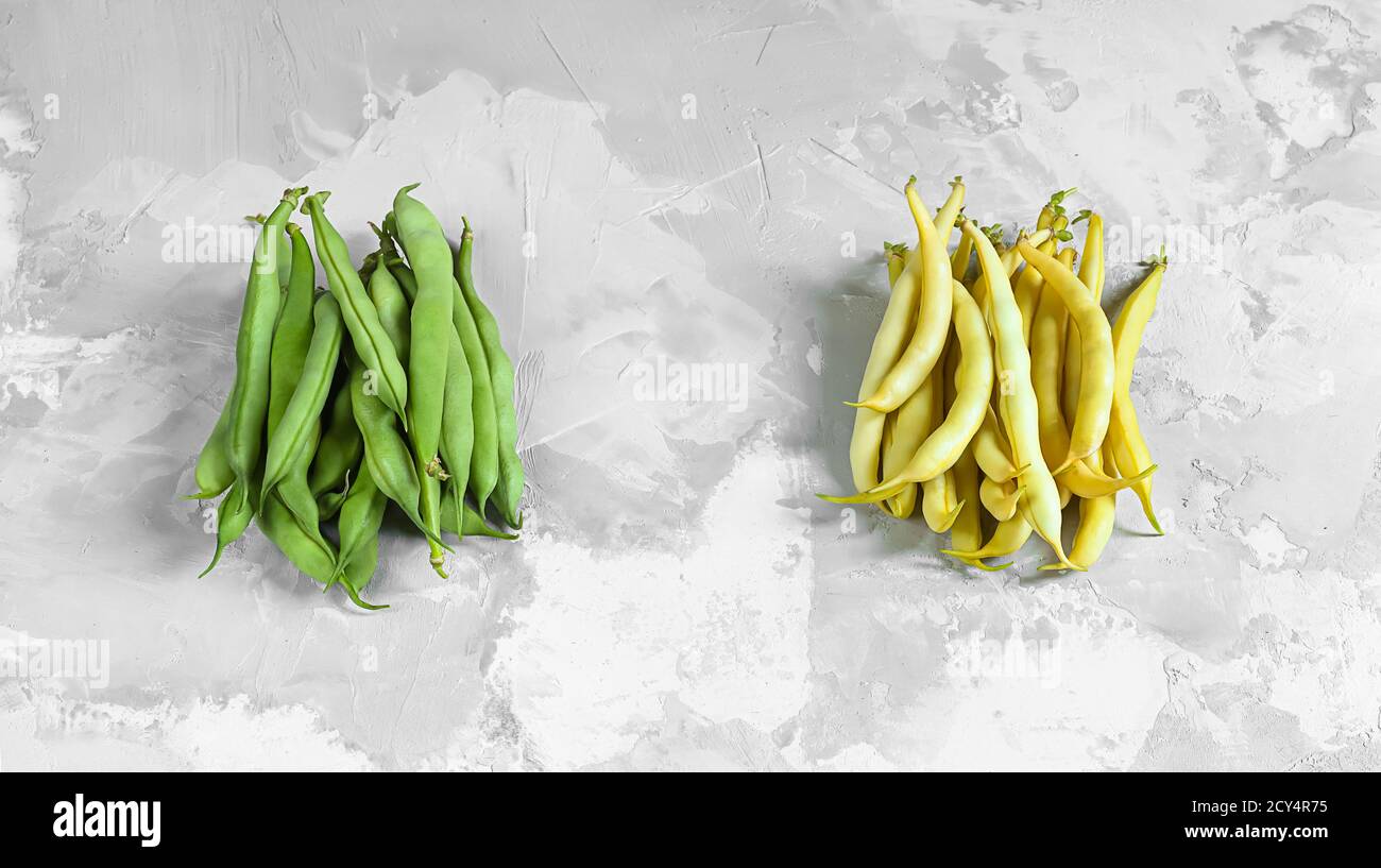 Green and yellow bean pods on gray background, top view Stock Photo