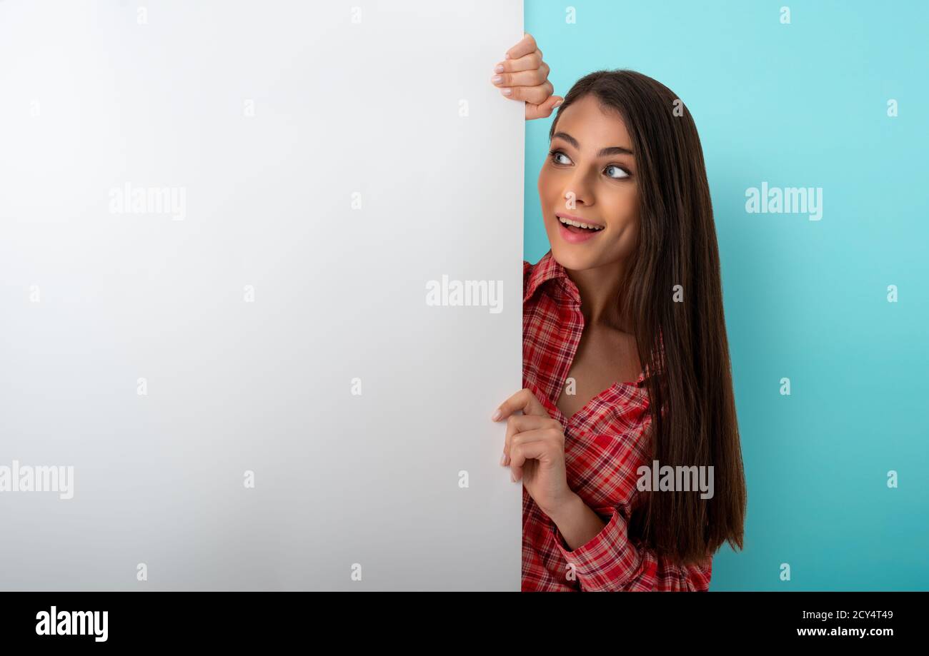 Brunette woman looks a white blank banner. free space for your text Stock Photo