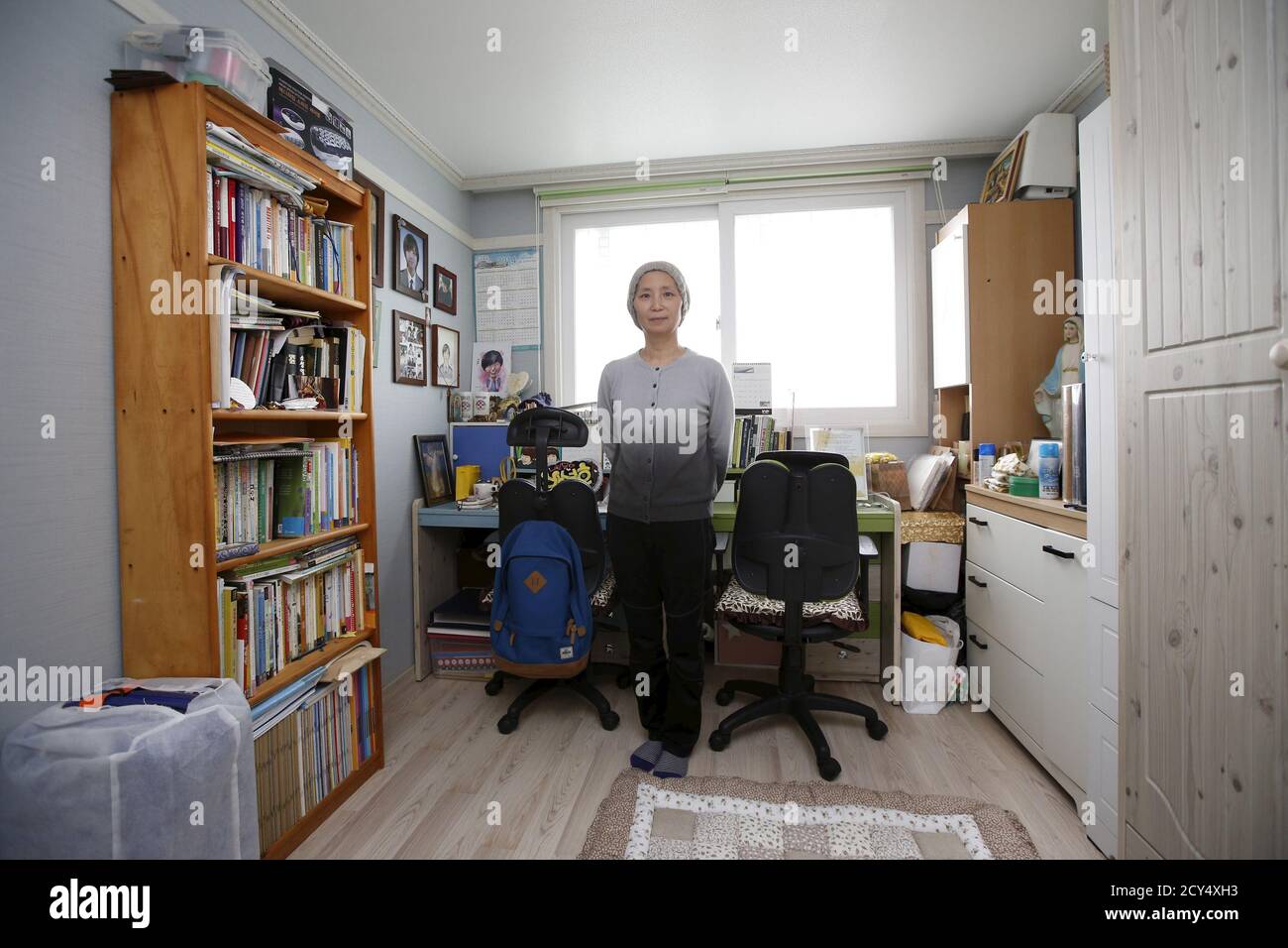 Jung Hye-suk, mother of Park Sung-ho, a high school student who died in the Sewol ferry disaster, poses for a photograph in her son's room in Ansan April 7, 2015. Jung said: 'Good children have died because of adults’ faults. The Sewol disaster taught us about the problems of our society and adults should make efforts to fix them, although it’s too late. We have to strive to prevent any reoccurrence of this disaster and to build a culture that cherishes human life. Our children didn’t blame society. They tried hard to save each others’ lives and worried about their families. Don’t we have to l Stock Photo