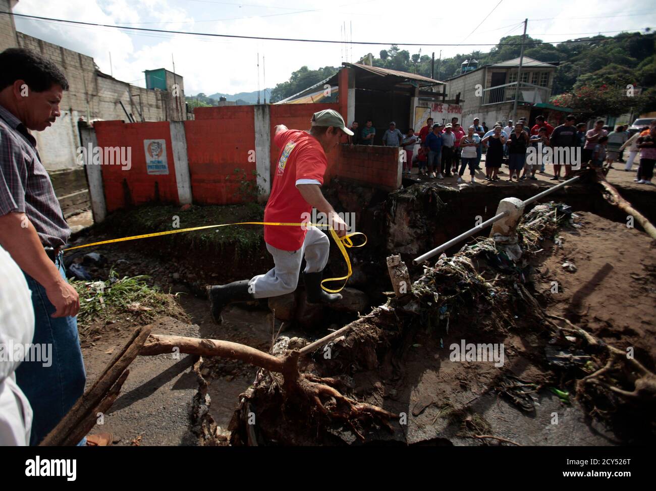 A man jumps across the remains of a destroyed bridge in El Porvenir, Villa  Canales, 20 kms (12 miles) from Guatemala City, August 14, 2011. The  bridge, already damaged since Storm Agatha