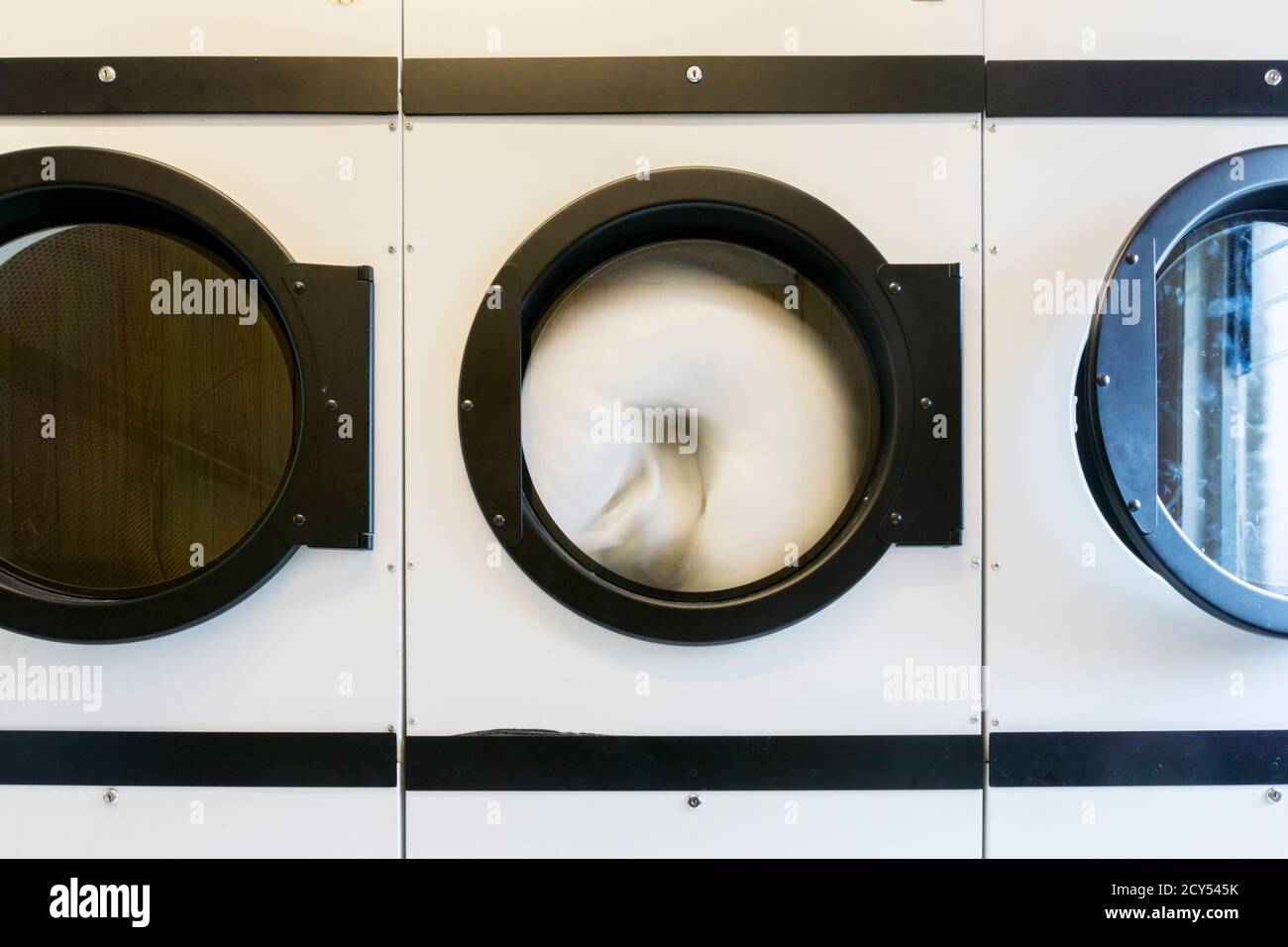 A duvet spinning in a launderette tumble drier Stock Photo Alamy