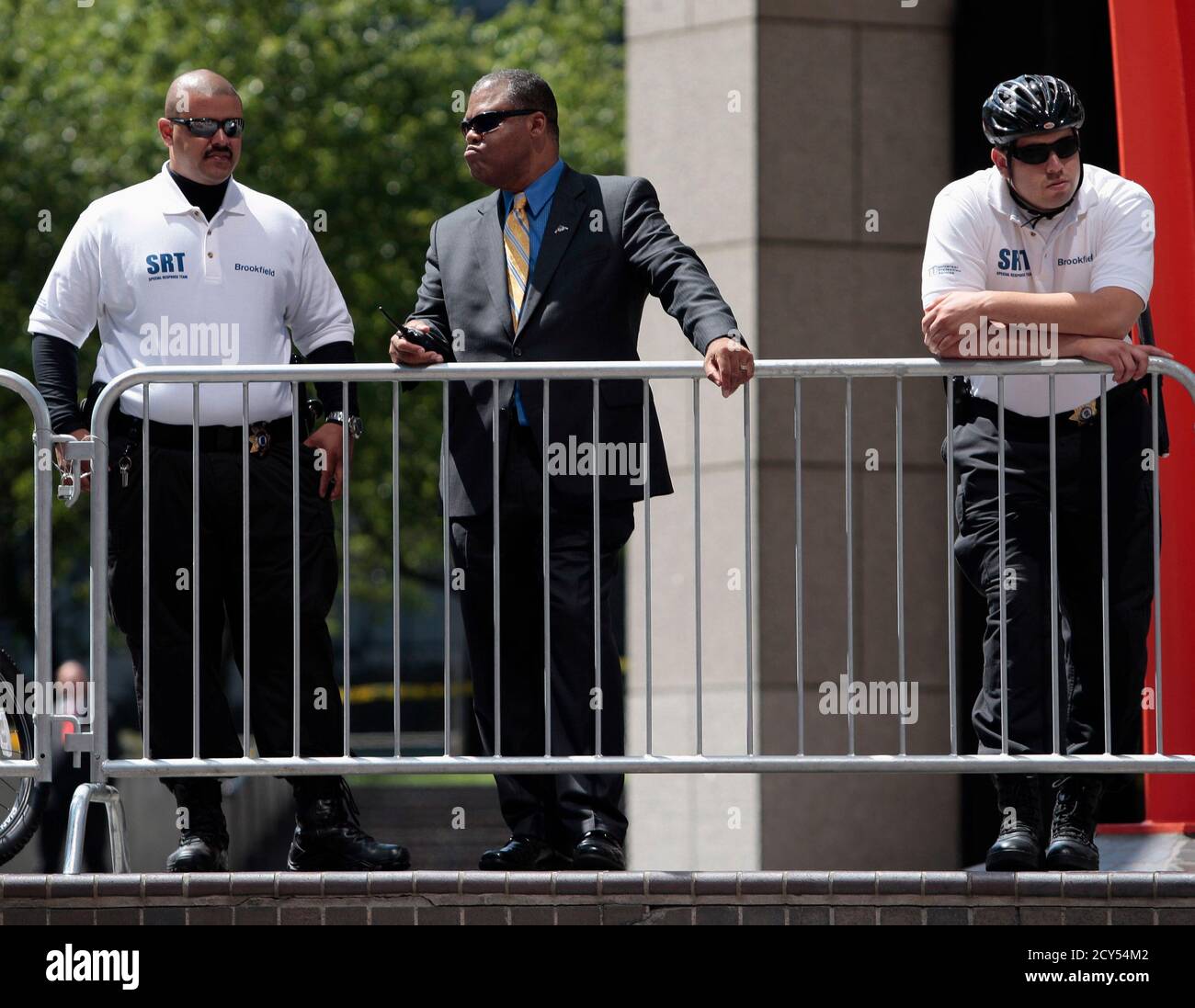 Security personnel watch as janitorial workers from the Service Employees  International Union (SEIU) United Service Workers West protest in front of  Bank of America Plaza on the final day of negotiations with
