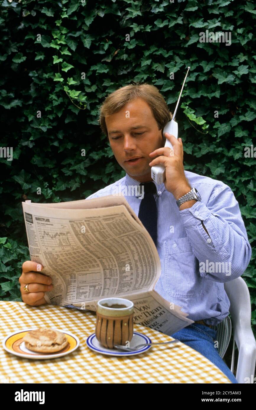 1990s BUSY BUSINESSMAN HAVING MORNING BREAKFAST SITTING EATING OUTDOOR READING A NEWSPAPER AND TALKING ON PHONE MULTITASKING - ks32545 NET002 HARS COMMUNICATION YOUNG ADULT INFORMATION LIFESTYLE HISTORY GROWNUP HOME LIFE COMMUNICATING COPY SPACE HALF-LENGTH PERSONS MALES MORNING SELLING HIGH ANGLE DISCOVERY EARLY AND NETWORKING KNOWLEDGE NUTRITION A ON OPPORTUNITY PHONES CONNECTION MULTITASKING TELEPHONES CELL CONSUME CONSUMING NOURISHMENT COOPERATION SALESMEN STOCK MARKET WRIST WATCH YOUNG ADULT MAN OLD FASHIONED Stock Photo