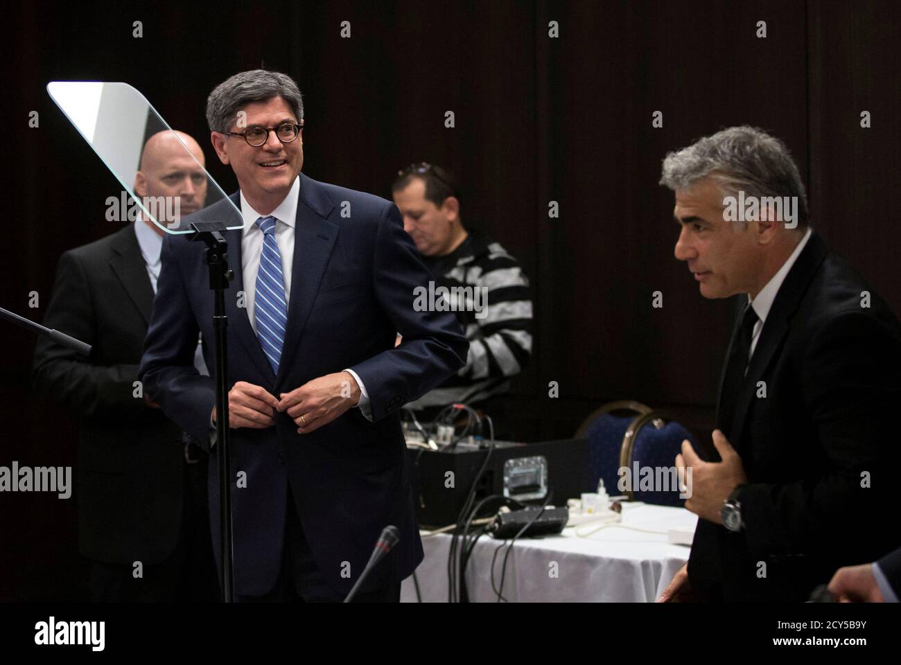 U.S. Treasury Secretary Jack Lew buttons his jacket near Israel's Finance Minister Yair Lapid (R) after Lew's speech to the U.S.-Israel Joint Economic Development Group in Jerusalem June 18, 2014. Lew said Iran's economy remained in a state of distress due to sanctions over its nuclear program and that the United States would not rush into making a bad deal to prevent Iran from obtaining a nuclear weapon. REUTERS/Baz Ratner (JERUSALEM - Tags: POLITICS BUSINESS ENERGY) Stock Photo