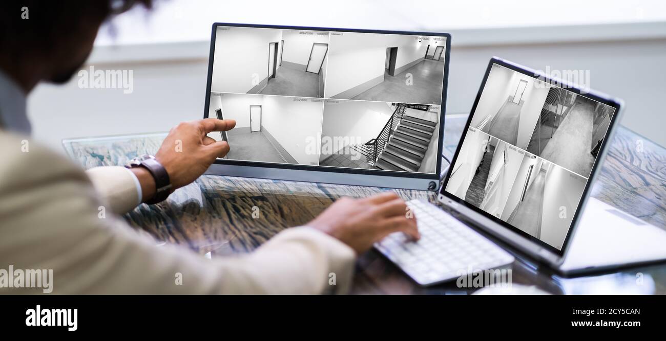 Security Guard Looking At CCTV Surveillance Video Footage Stock Photo