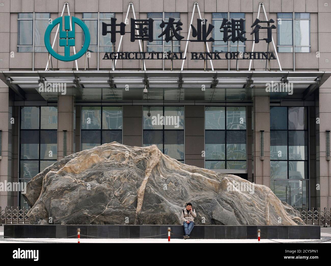 A Man Uses A Mobile Phone In Front Of The Headquarters Of Agricultural Bank Of China In Beijing April 23 2013 Agricultural Bank Of China The Country S No 3 Lender Reported First Quarter Earnings