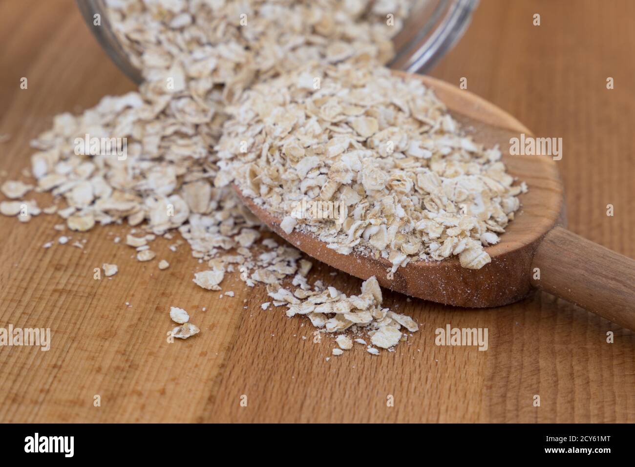 close-up of porridge oats on a wooden spoon and a glass bowl Stock Photo