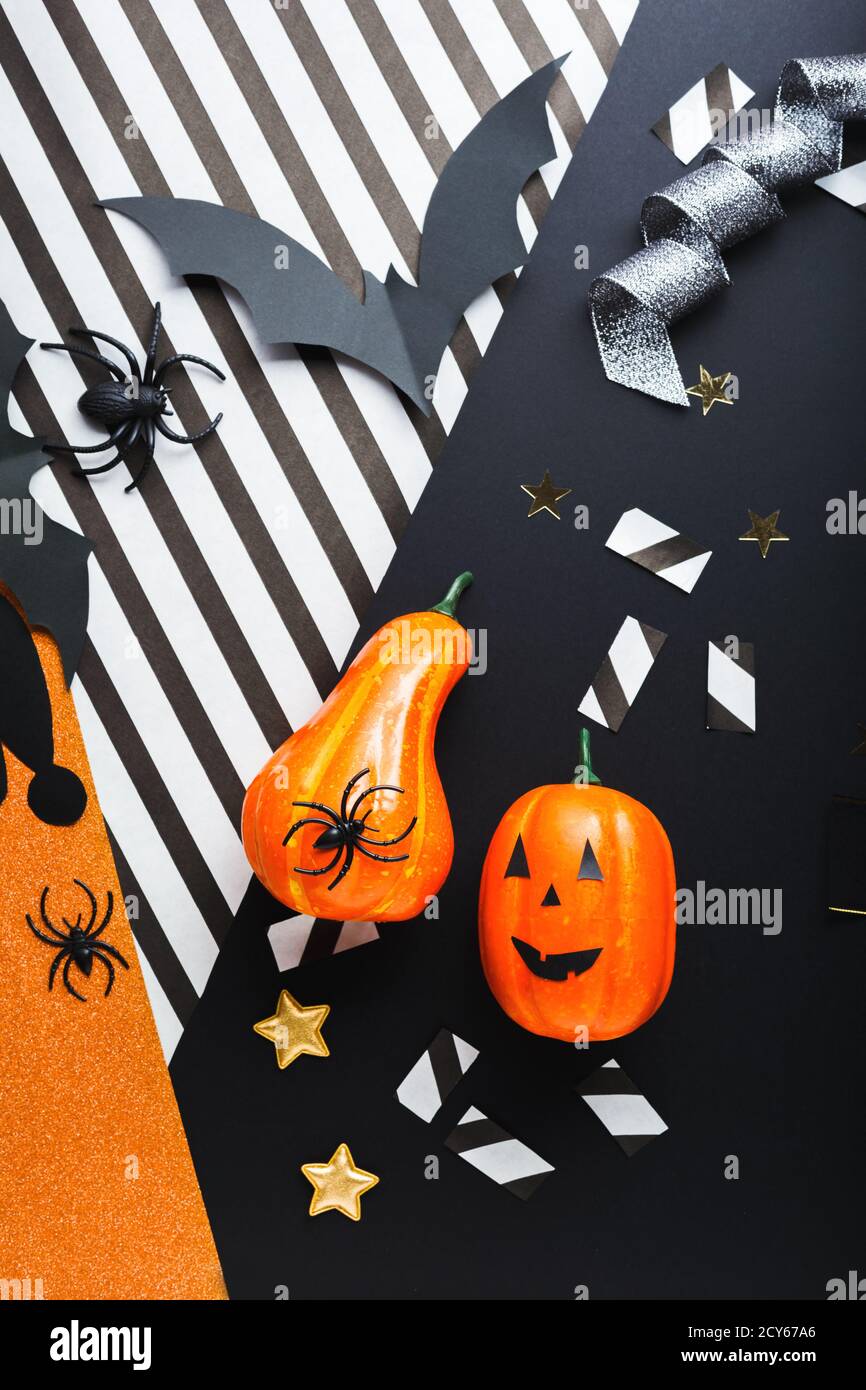 Halloween party invitation mockup, celebration. Halloween decorations concept with bats, spiders, jack-o'-lantern, stars, confetti, ribbon. Flat lay Stock Photo