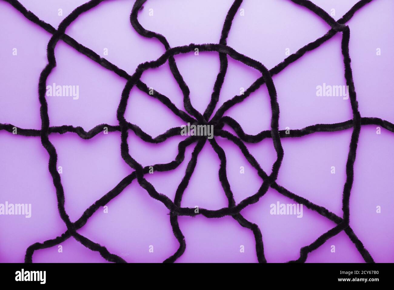 Giant spider web on a puple background. Halloween decorations concept. Flat lay, top view, copy space. Stock Photo