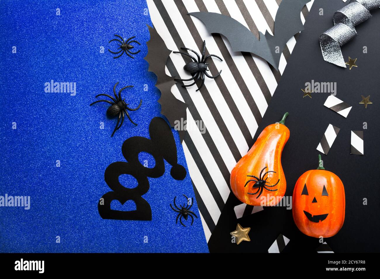 Halloween party invitation mockup, celebration. Halloween decorations concept with bats, spiders, jack-o'-lantern, stars, confetti, ribbon. Flat lay Stock Photo