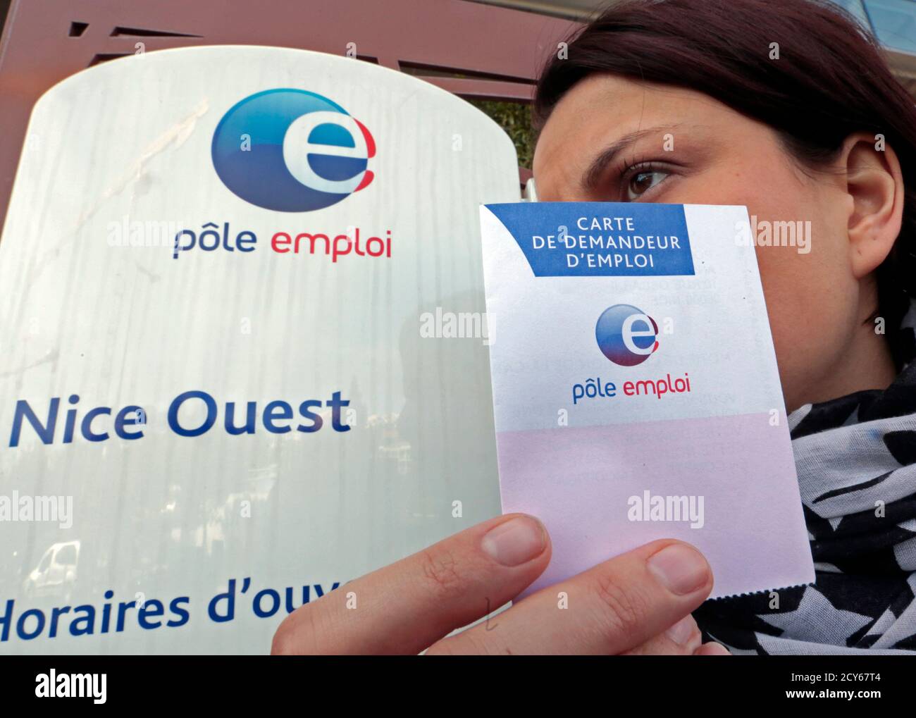 A woman holds her job seeker's card outside a National Agency for  Employment (Pole Emploi), in Nice February 27, 2013. The number of people  out of work in France shot up again