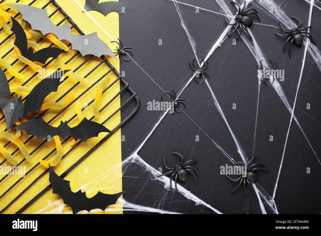 Halloween background with sweet candy, worms, paper bats, spiders and ...