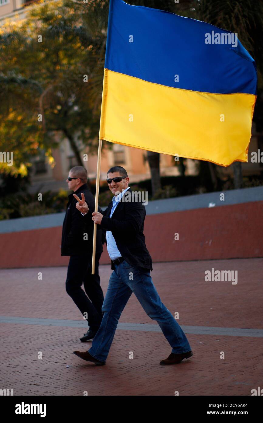 A Ukrainian living in Malaga flashes a victory sign as he holds a Ukrainian flag during a protest against Russian President Vladimir Putin and in favor of unity and democratic freedom in Ukraine, in downtown Malaga, southern Spain, March 16, 2014. France on Sunday demanded Russia immediately take measures to reduce 'pointless and dangerous' tensions in Ukraine, calling the secession referendum held in the Crimea region illegal. REUTERS/Jon Nazca (SPAIN - Tags: POLITICS CIVIL UNREST ELECTIONS) Stock Photo
