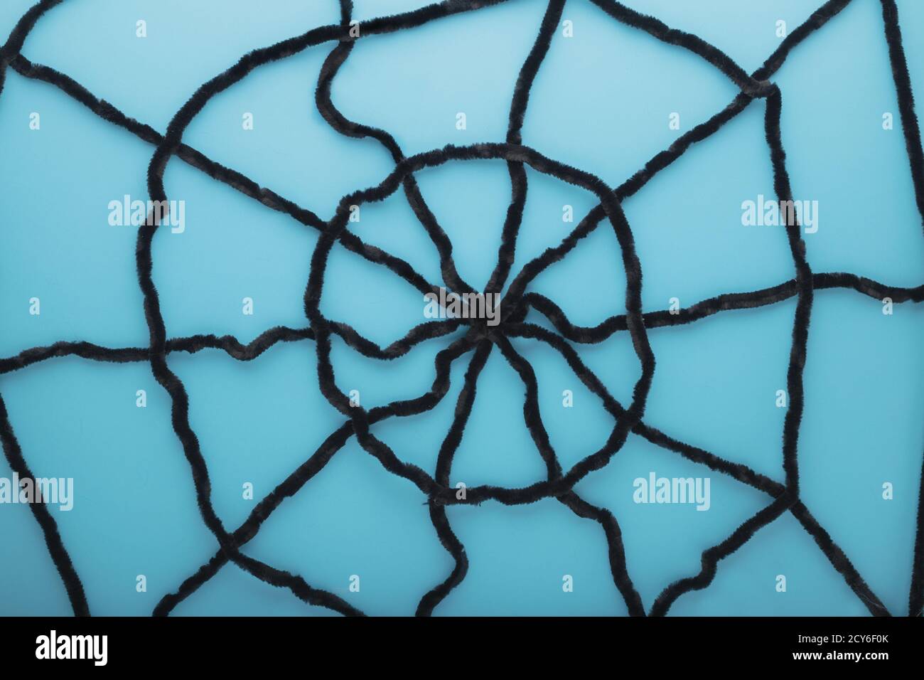 Giant spider web on a blue background. Halloween decorations concept. Flat lay, top view, copy space. Stock Photo