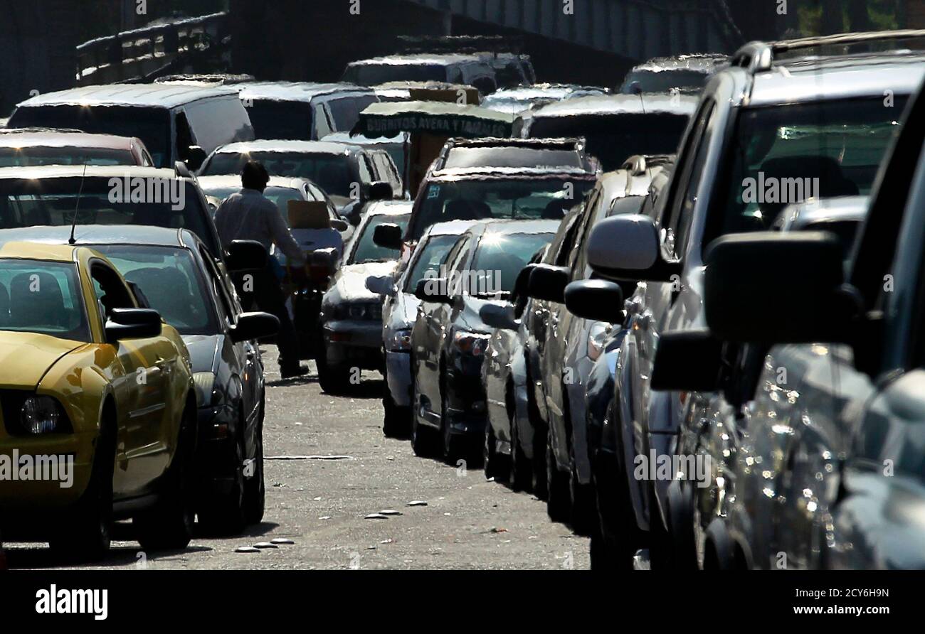 Vehicles line up in the heat as they head into the U.S. from Mexico at San Ysidro border in California September 27, 2011. With over 13 million vehicles a year, 24 lanes of traffic and 18,000 pedestrians a day, the task of risk management happens 24 hours a day, seven days a week at the U.S.-Mexican border in San Ysidro, California. Hundreds of customs and border protection officers use sophisticated technology to protect the busiest land border crossing in the U.S. The world's population is projected to reach 7 billion on October 31, 2011, according to official U.N. population projections, pr Stock Photo