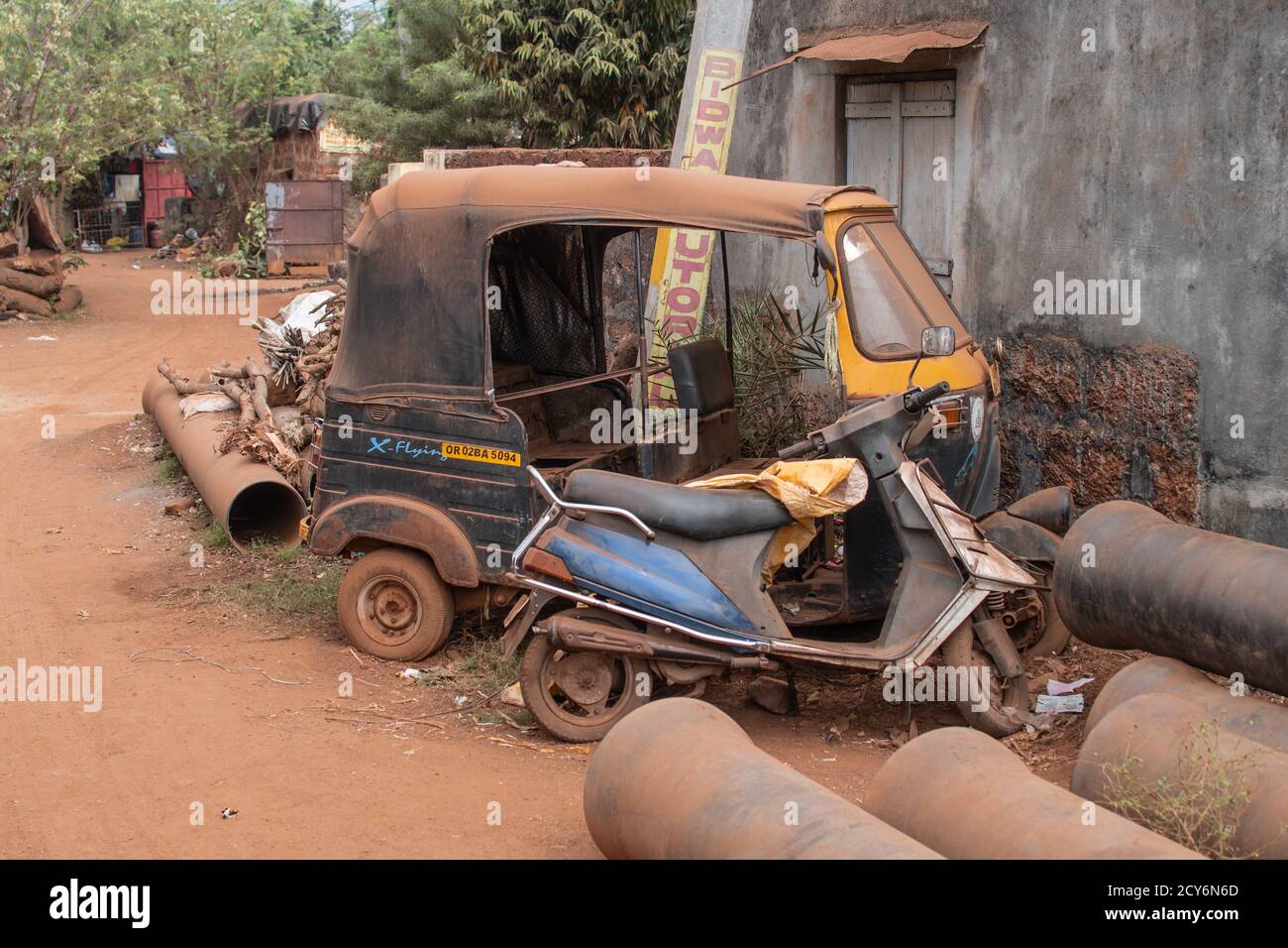 Bhubaneswar, India - February 4, 2020: An old abandoned auto rickshaw and a motorbike covered in dust and dirt on February 4, 2020 in Bhubaneswar Stock Photo