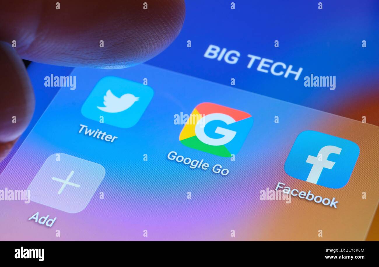 Google, Facebook, Twitter apps seen on the screen and blurred finger pointing at them. Stock Photo