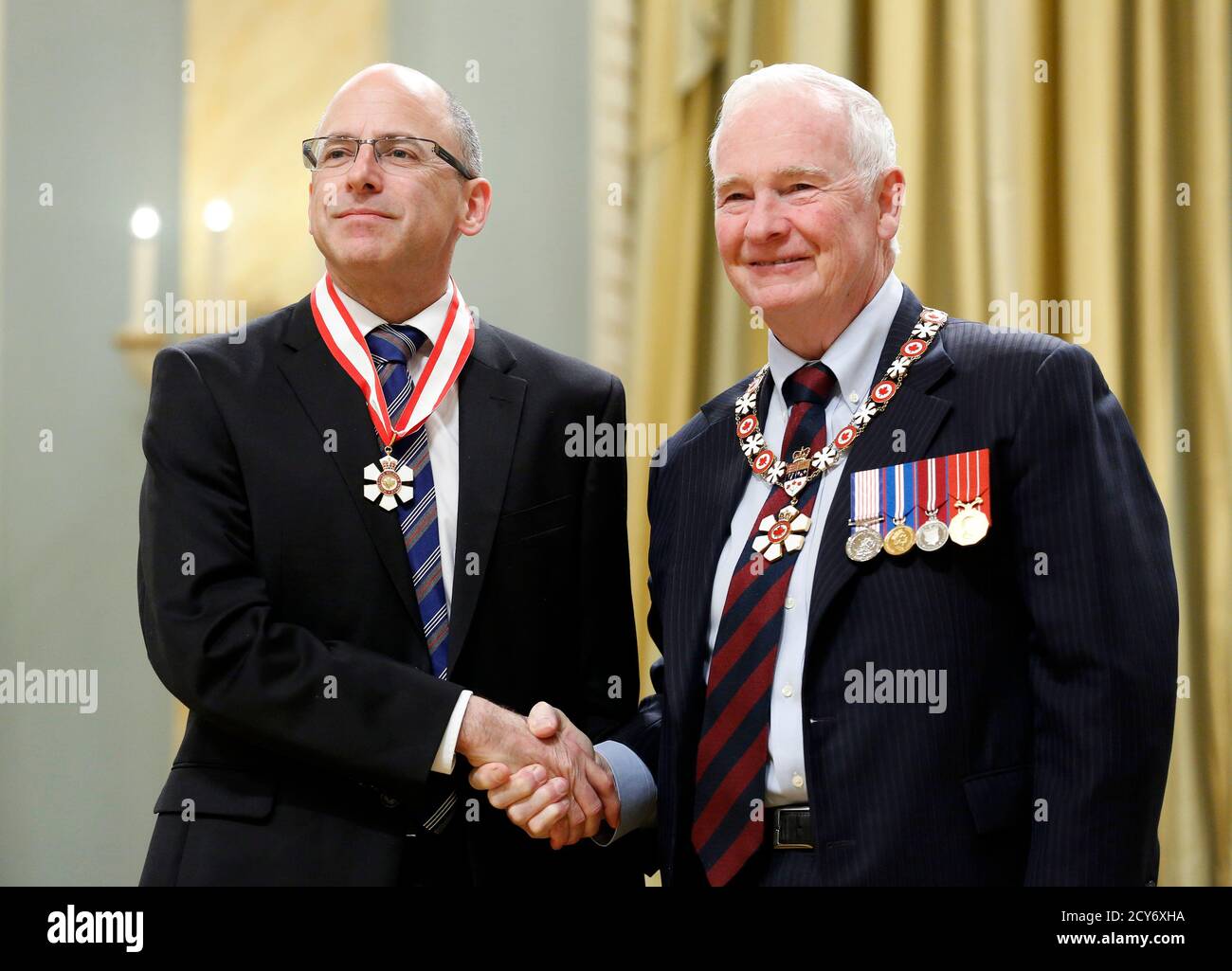 Genome scientist Thomas Hudson (L) poses with Governor General David  Johnston after being awarded the rank of Officer in the Order of Canada  during a ceremony at Rideau Hall in Ottawa November