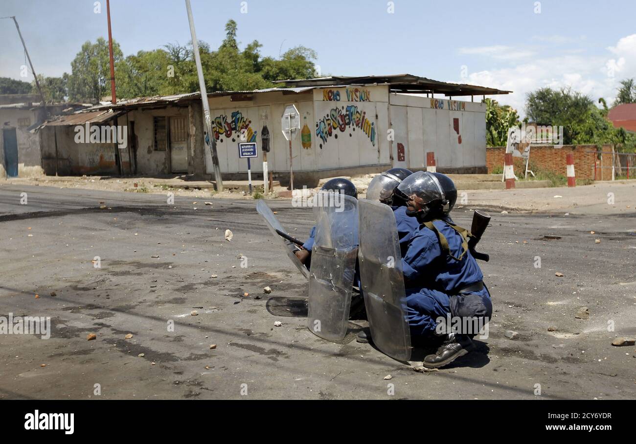 Riot policemen hold their positions as they clash with protesters in Burundi's capital Bujumbura, April 28, 2015. Hundreds of people marched in the outskirts of Burundi's capital on Tuesday in a third day of protests against President Pierre Nkurunziza's decision to run for a third term, a move critics say violates the constitution and a key peace deal. REUTERS/Thomas Mukoya Stock Photo