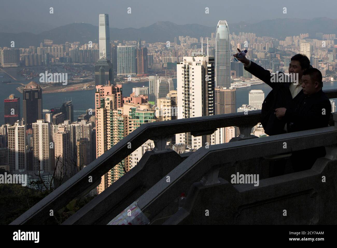 A mainland Chinese businessman points at a building from the Peak, a popular sightseeing spot for tourists, in Hong Kong January 14, 2014. Launched by the Hong Kong government over a decade ago to stimulate an economy battered by the Severe Acute Respiratory Syndrome (SARS) crisis, the Hong Kong Capital Investment Entrant Scheme has proved a hit with mainland Chinese who, though technically barred, see it as a means to invest money near home without the tight controls imposed by Beijing. Although governed by Beijing, Hong Kong has a high degree of autonomy. Picture taken January 14, 2014.    R Stock Photo