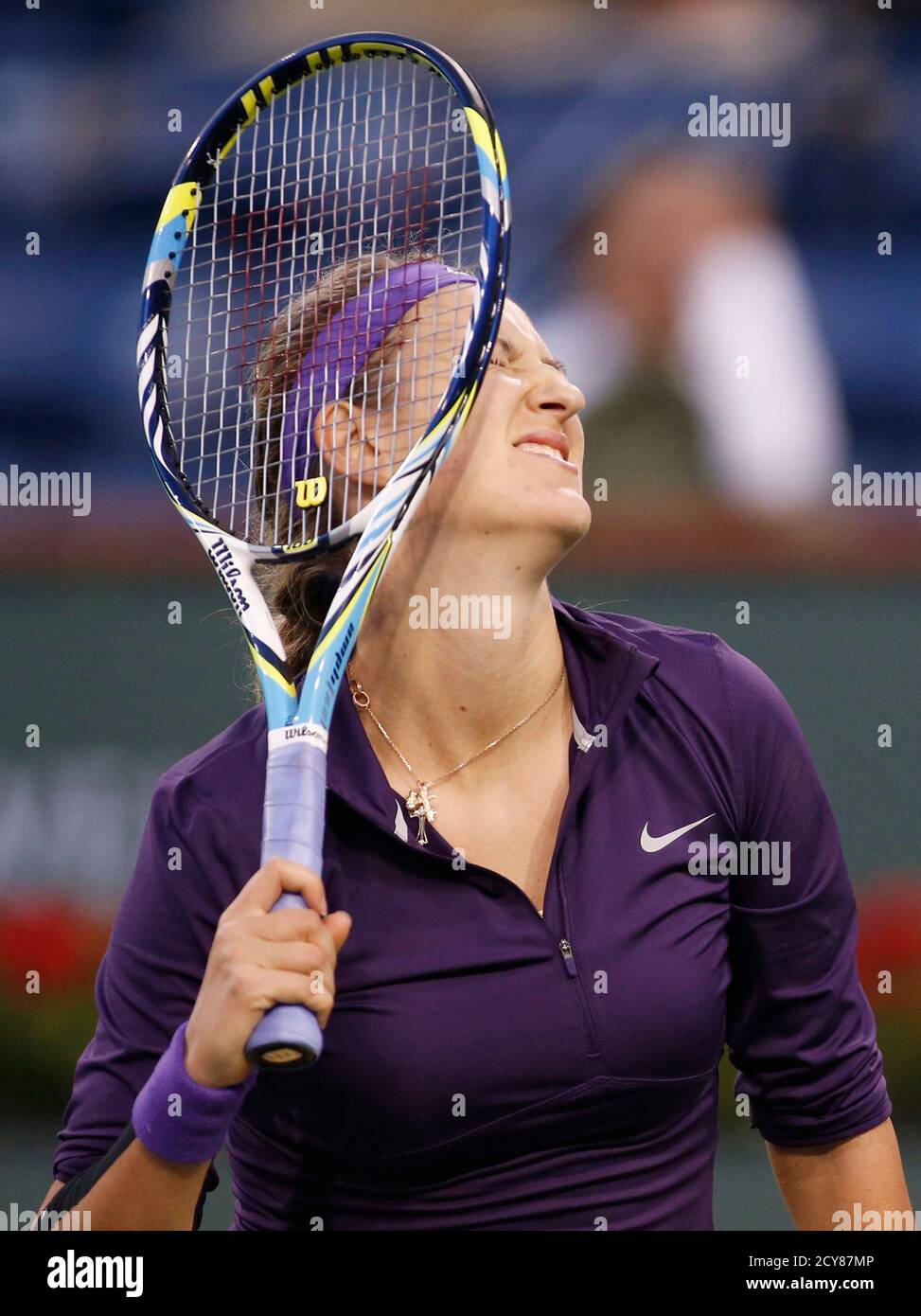 Victoria Azarenka of Belarus bounces the strings of her racket on her head  after losing a point against Daniela Hantuchova of Slovakia during their  match at the BNP Paribas Open WTA tennis