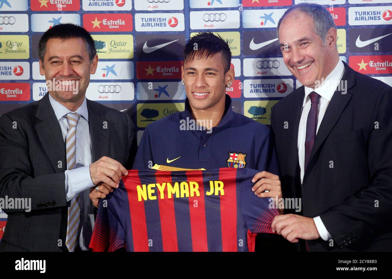 Brazilian soccer player Neymar (C) poses with his new jersey next to sports director Andoni Zubizarreta (R) and vice-president Ferran Bartomeu (L) after signing a five-year contract in Barcelona June 3, 2013. REUTERS/Albert Gea (SPAIN - Tags: SPORT SOCCER) Stock Photo