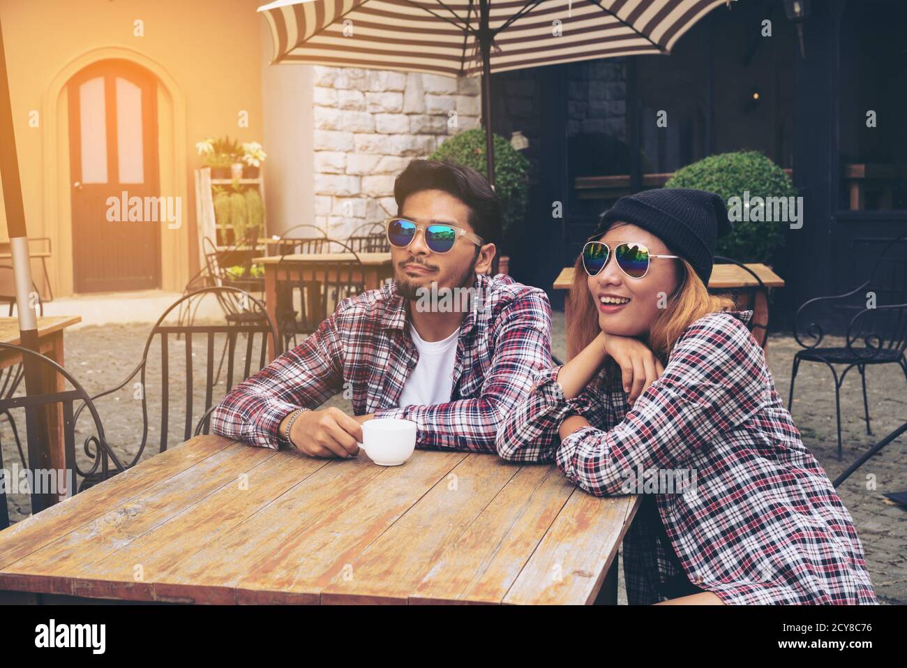 Asian and Arabic students couple hanging out in cafe european style Stock Photo