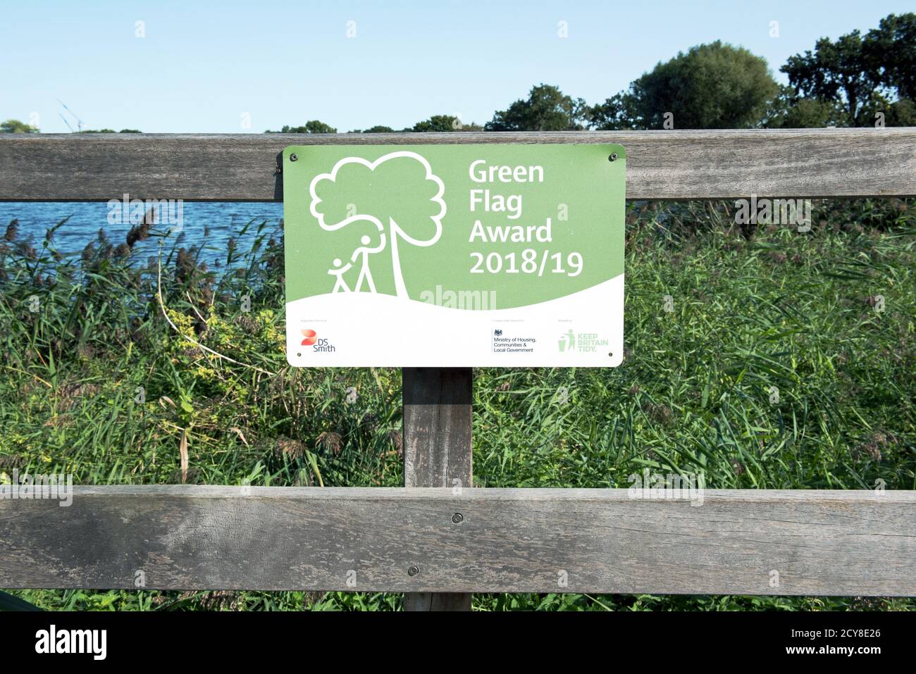 Green flag award sign on fence with reservoir behind Woodberry Wetlands urban nature reserve run by the London WildlifeTrust, Stoke Newington, London Stock Photo