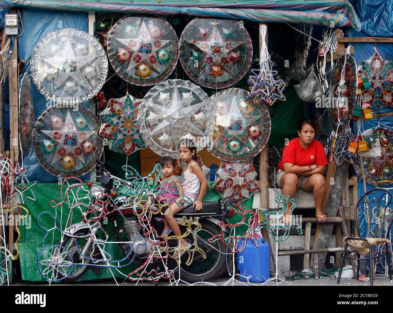 A Mother And Her Children Wait For Customers Beside Their Christmas Decorations For Sale Along A Busy Street In Manila December 11 2010 The Philippines Celebrates One Of The Longest Christmas Seasons