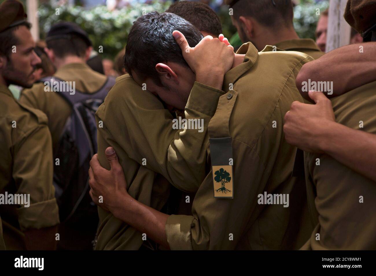 Israeli soldiers from the Golani Brigade mourn during the funeral for their fallen comrade Max Steinberg at Mount Herzl military cemetery in Jerusalem July 23, 2014. Steinberg, a 23 year-old American from California's San Fernando Valley, was among 13 Israeli Defense Forces soldiers killed on Sunday during fighting in Gaza. REUTERS/Siegfried Modola (JERUSALEM - Tags: CONFLICT POLITICS CIVIL UNREST MILITARY TPX IMAGES OF THE DAY) Stock Photo