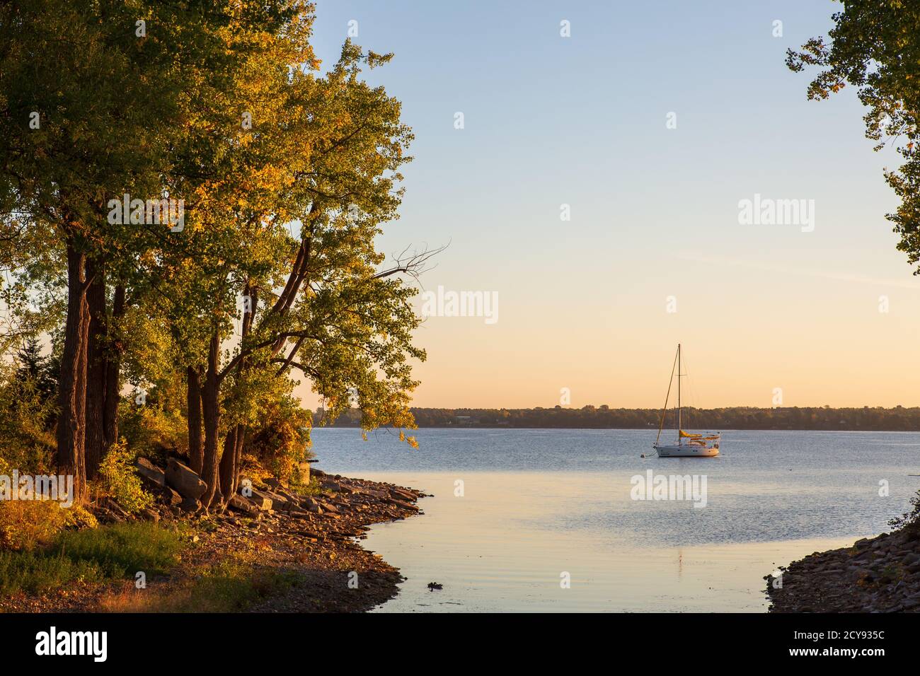 Sailboat at anchor in a beautiful bay just before sunrise in the fall Stock Photo