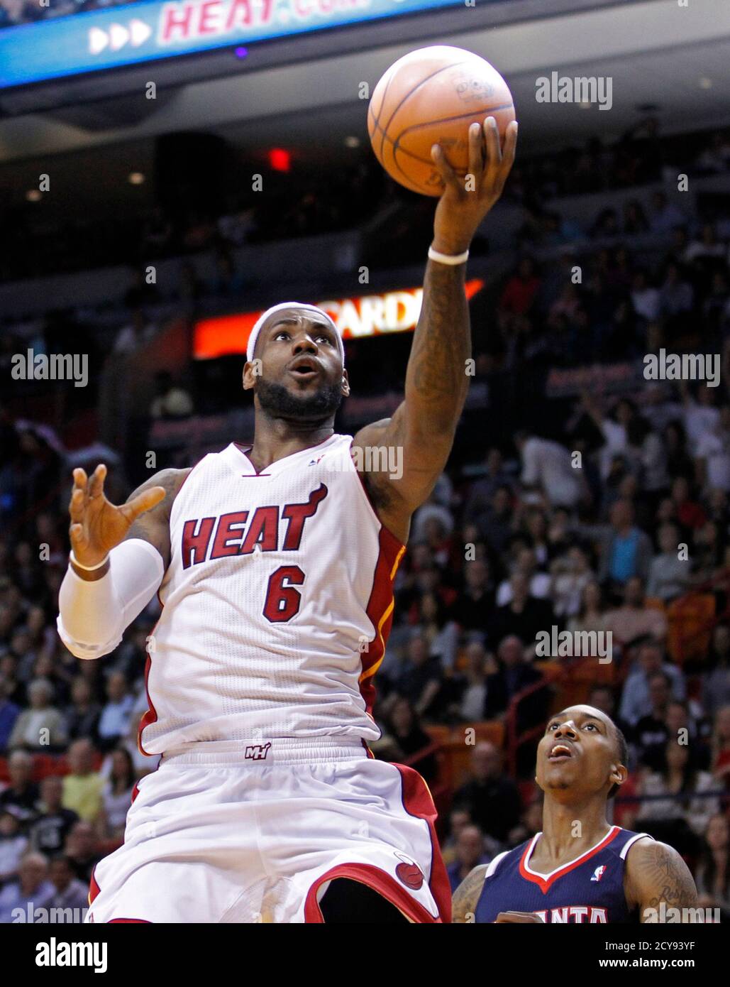 Miami Heat small forward LeBron James (L) drives past Atlanta Hawks guard  Jeff Teague to score in the first quarter during their NBA basketball game  in Miami, Florida, January 2, 2012. REUTERS/Joe