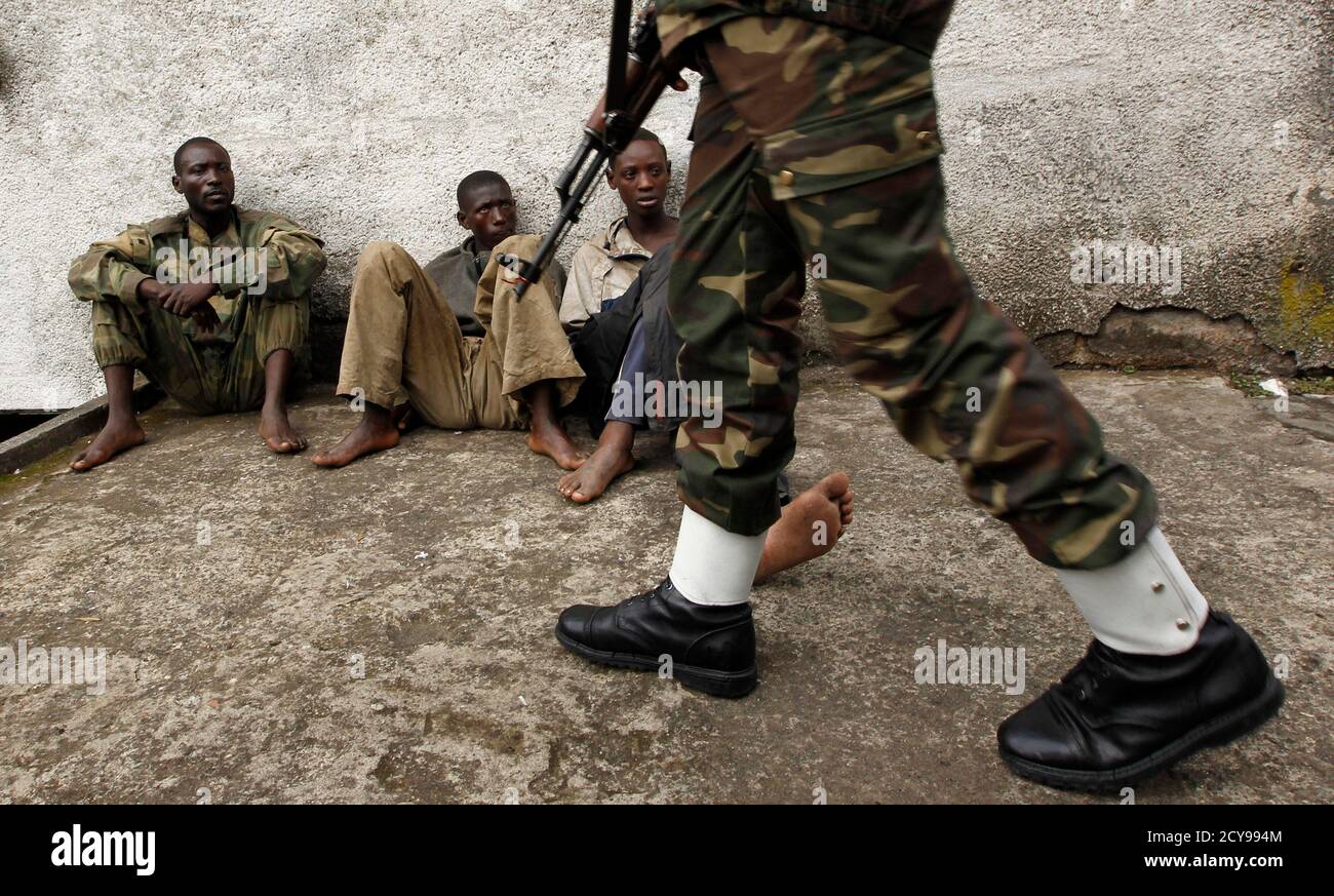 A Congolese soldier guards suspected rebels arrested during an operation against M23 rebels in Goma September 2, 2013. Fighting erupted between eastern Congolese rebels and the army, which said it would push on with an offensive to recapture all territory controlled by insurgents despite their call for a ceasefire. REUTERS/Thomas Mukoya (DEMOCRATIC REPUBLIC CONGO - Tags: CIVIL UNREST MILITARY POLITICS TPX IMAGES OF THE DAY) Stock Photo